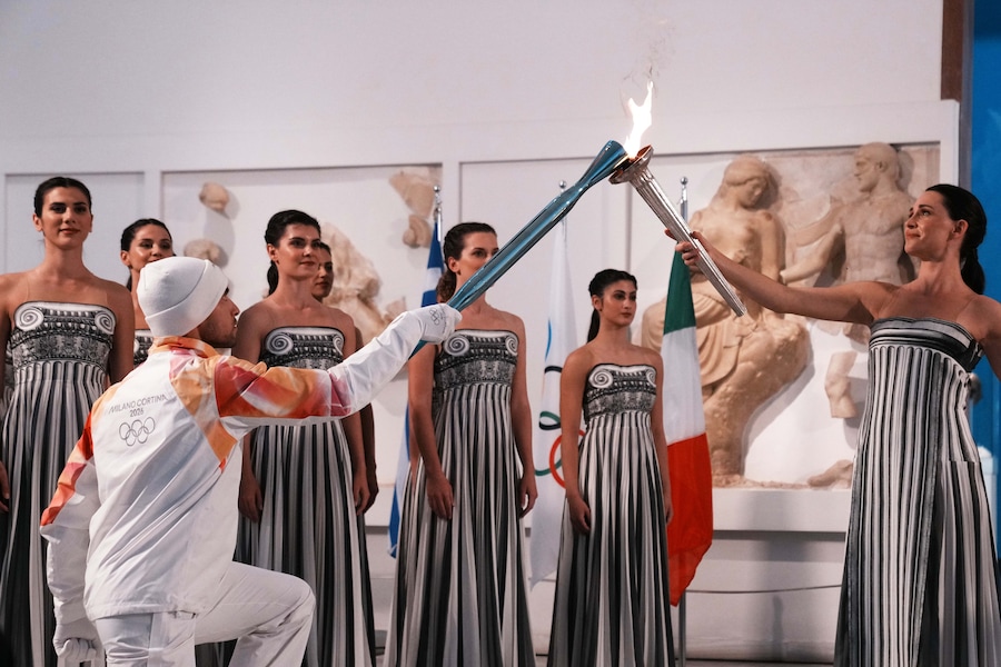 L'attrice Mary Mina, a destra, nel ruolo di sacerdotessa, passa la fiamma olimpica al primo tedoforo, il canottiere greco Petros Gaidatzis, durante la cerimonia di accensione della fiamma per le Olimpiadi invernali di Milano Cortina 2026, al museo archeologico di Olimpia, in Grecia, mercoledì 26 novembre 2025. (Foto AP/Thanassis Stavrakis) (APS)