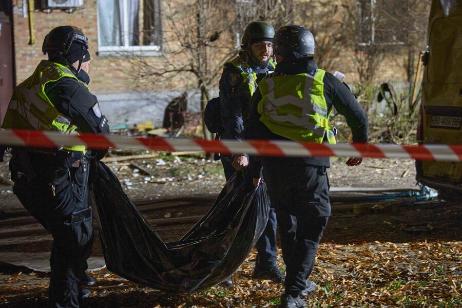 Poliziotti trasportano il corpo di un civile ucciso da un drone che ha colpito un edificio residenziale durante l'attacco notturno di missili e droni della Russia a Kiev. (APN)