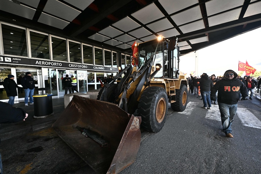 I lavoratori dell'ex Ilva di Genova Cornigliano, ai quali si sono aggiunti i lavoratori di Ansaldo Energia, anch'essi in sciopero, sono arrivati davanti all'aeroporto di Genova 'Cristoforo Colombo' collocando davanti alle porte una pala meccanica, bloccando così l'ingresso dell'area 'partenze', Genova, 2 dicembre 2025. ANSA/LUCA ZENNARO (ANSA)
