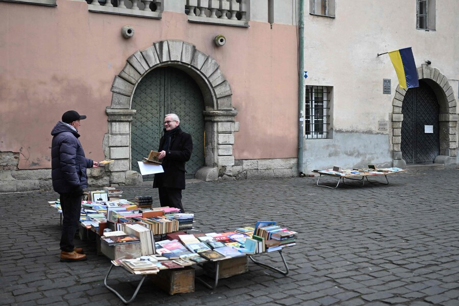 Un uomo (a destra) parla con un venditore ambulante mentre visita un mercato delle pulci a Leopoli, durante l'invasione russa dell'Ucraina. (Sergei Gapon / AFP)