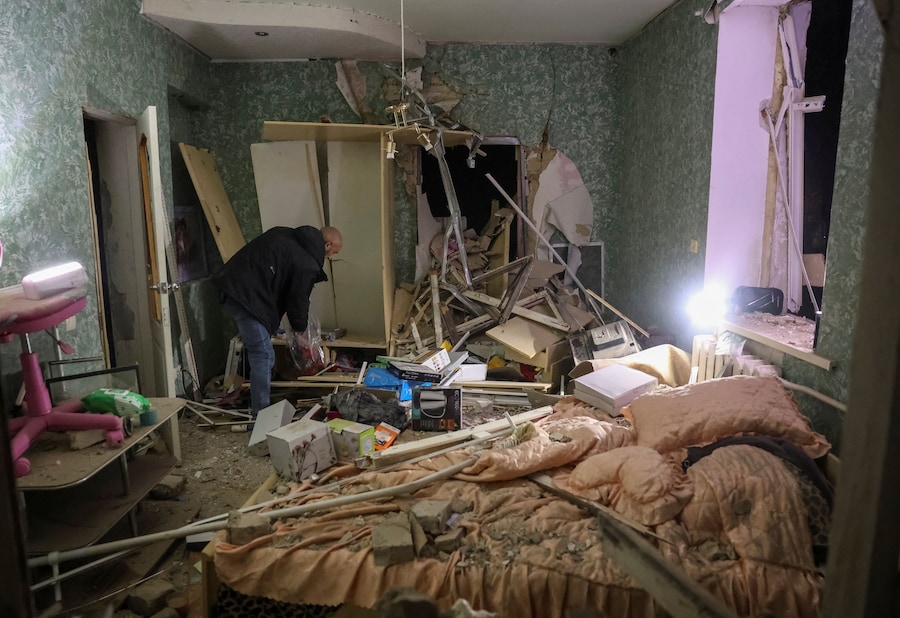 Un residente raccoglie oggetti nel suo appartamento in un condominio danneggiato da un attacco aereo russo, a Sloviansk, Ucraina. (REUTERS/Anatolii Stepanov)