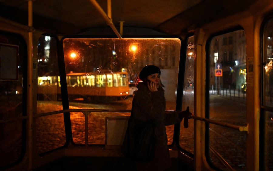Una donna parla al cellulare mentre sale su un tram a Lviv. (Foto di Sergei Gapon / AFP)