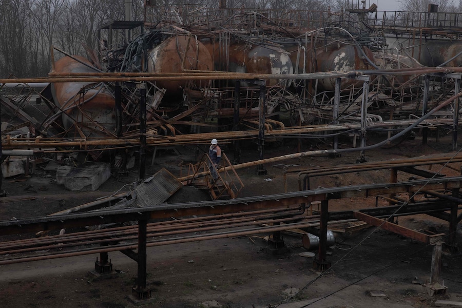 Un dipendente passa davanti alle parti danneggiate dell'impianto di gas Naftogaz, in seguito agli attacchi missilistici e dei droni russi. (Roman Pilipey / AFP)