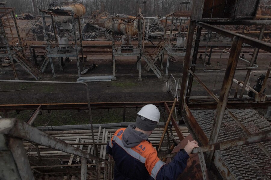 Un dipendente cammina nell'area danneggiata dell'impianto di gas Naftogaz, in seguito agli attacchi missilistici e dei droni russi, in Ucraina. (Roman Pilipey / AFP)