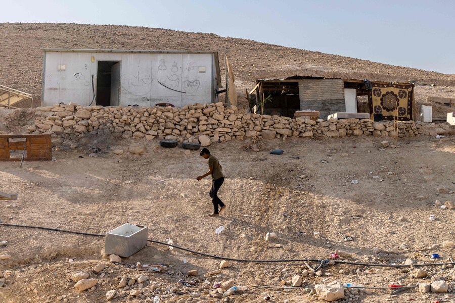 Un giovane beduino palestinese passa davanti alle case del villaggio di Kaabna, vicino a Gerico, nella Cisgiordania occupata, il 6 novembre 2025. Israele occupa la Cisgiordania dal 1967 e la violenza è aumentata dopo la guerra di Gaza scoppiata nell'ottobre 2023 in seguito all'attacco di Hamas a Israele. Circa 3.200 palestinesi di decine di comunità beduine e di pastori sono stati costretti ad abbandonare le loro case dalla violenza dei coloni e dalle restrizioni di movimento dall'ottobre 2023, come ha riferito l'agenzia umanitaria delle Nazioni Unite OCHA in ottobre. (Foto di Menahem Kahana / AFP) (AFP)