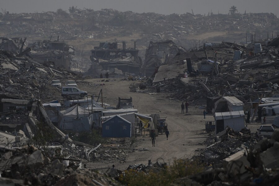 Palestinesi camminano tra le distruzioni lasciate dall'offensiva aerea e di terra israeliana a Gaza City, venerdì 5 dicembre 2025. (Foto AP/Abdel Kareem Hana) (APN)