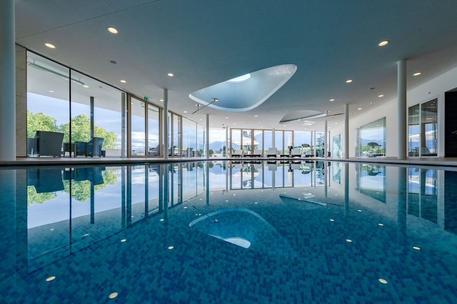 La piscina interna di Clinique La Prairie: uno spazio luminoso e silenzioso pensato per il recupero, il rilassamento profondo e il benessere fisico, con vista sulla natura circostante.