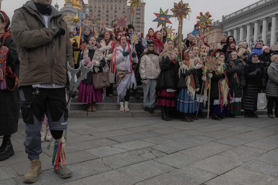 Ucraini in abiti tradizionali cantano l'inno nazionale ucraino in Piazza Indipendenza mentre partecipano a una processione natalizia nel centro di Kiev il 25 dicembre 2025, durante l'invasione russa dell'Ucraina. (Foto di Roman PILIPEY / AFP) (AFP)