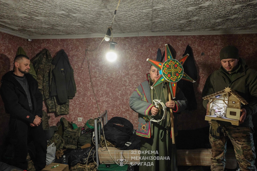 Questa foto scattata il 25 dicembre 2025 e diffusa dal servizio stampa della 33esima brigata meccanizzata separata delle Forze armate ucraine mostra il cappellano militare Mykola che canta un canto durante una visita ai militari della 33esima brigata meccanizzata separata il giorno di Natale nella regione di Donetsk, durante l'invasione russa dell'Ucraina. (Foto di Volodymr PETROV / Servizio stampa della 33ª Brigata meccanizzata separata delle Forze armate ucraine / AFP) (AFP)