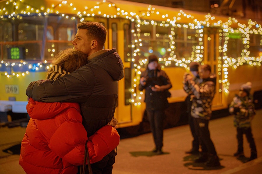 Una coppia si abbraccia vicino ai tram decorati con ghirlande nel giorno di Natale a Kharkiv, il 25 dicembre 2025, durante l'invasione russa dell'Ucraina. (Foto di Ivan SAMOILOV / AFP) (AFP)