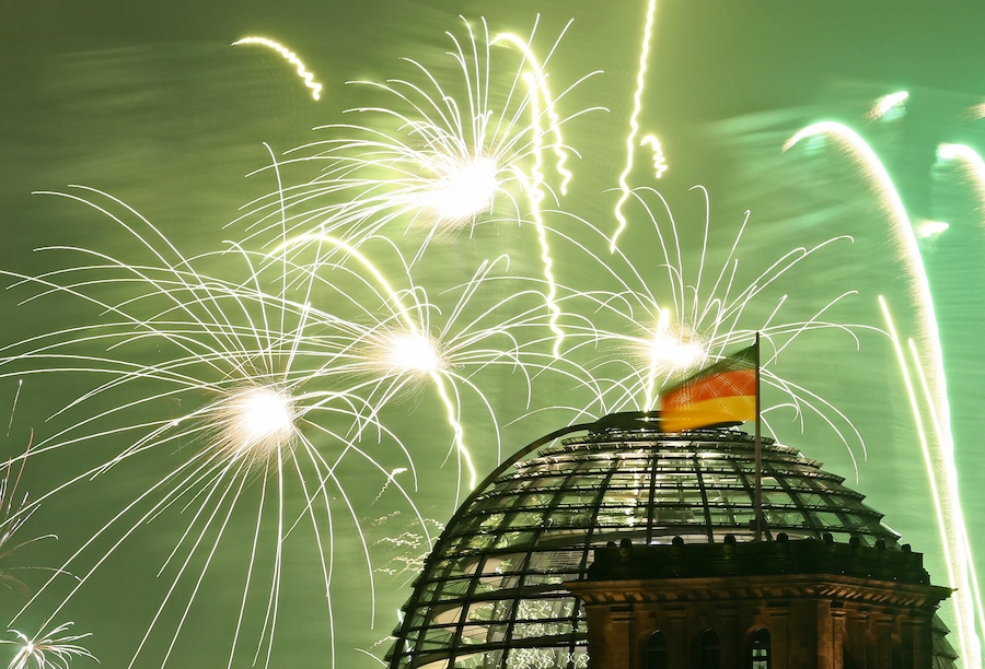 Fuochi d'artificio esplodono sulla cupola di vetro del palazzo del Reichstag e sulla bandiera nazionale tedesca in occasione dei festeggiamenti per il nuovo anno a Berlino, Germania, 1 gennaio 2026. (REUTERS/Lisi Niesner)