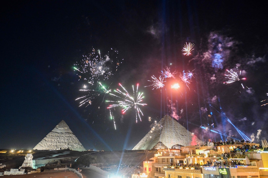 Fuochi d'artificio illuminano il cielo sopra le Grandi Piramidi di Giza, alla periferia del Cairo, durante i festeggiamenti per il nuovo anno, all'inizio del 1° gennaio 2026. (Ahmed Hasan / AFP)