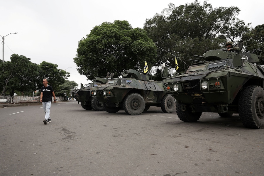 Un uomo cammina accanto a veicoli militari mentre i soldati colombiani pattugliano il confine tra Venezuela e Colombia, dopo che il presidente statunitense Donald Trump ha dichiarato che gli Stati Uniti hanno colpito il Venezuela e catturato il suo presidente Nicolas Maduro, a Cucuta, Colombia, 3 gennaio 2026. REUTERS/Luisa Gonzalez (REUTERS)