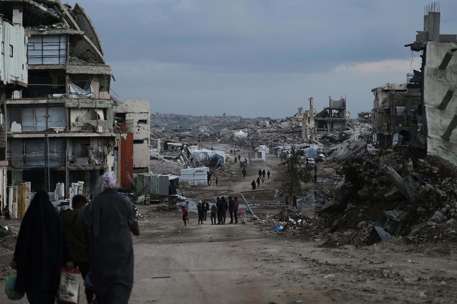 I palestinesi camminano tra gli edifici distrutti dalle operazioni aeree e terrestri israeliane nel quartiere Zeitoun della città di Gaza. (AP Photo/Jehad Alshrafi) (APN)