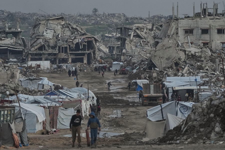 I palestinesi camminano tra gli edifici distrutti dalle operazioni aeree e terrestri israeliane nel quartiere Zeitoun della città di Gaza. (AP Photo/Jehad Alshrafi) (APN)