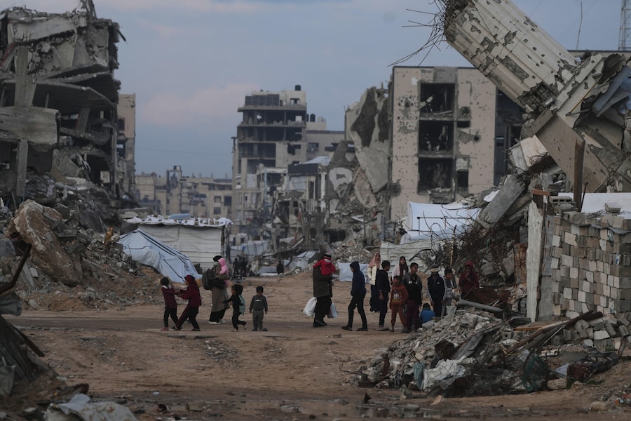 I palestinesi camminano tra gli edifici distrutti dalle operazioni aeree e terrestri israeliane nel quartiere Zeitoun della città di Gaza. (AP Photo/Jehad Alshrafi) (APN)