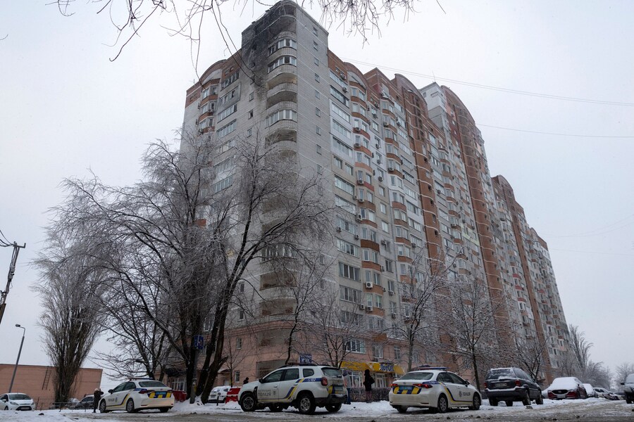 I veicoli della polizia parcheggiati fuori da un condominio dopo che un drone russo ha colpito i piani superiori dell'edificio. Kiev, Ucraina, il 15 gennaio 2026. (REUTERS)