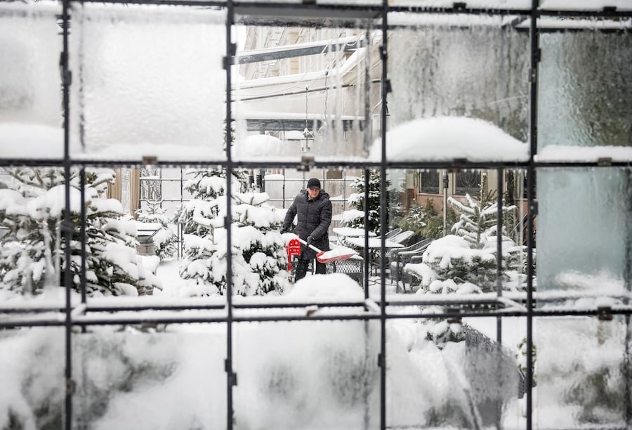 Un uomo pulisce la neve dalla terrazza di un ristorante a Kiev, Ucraina, 15 gennaio 2026. (REUTERS)