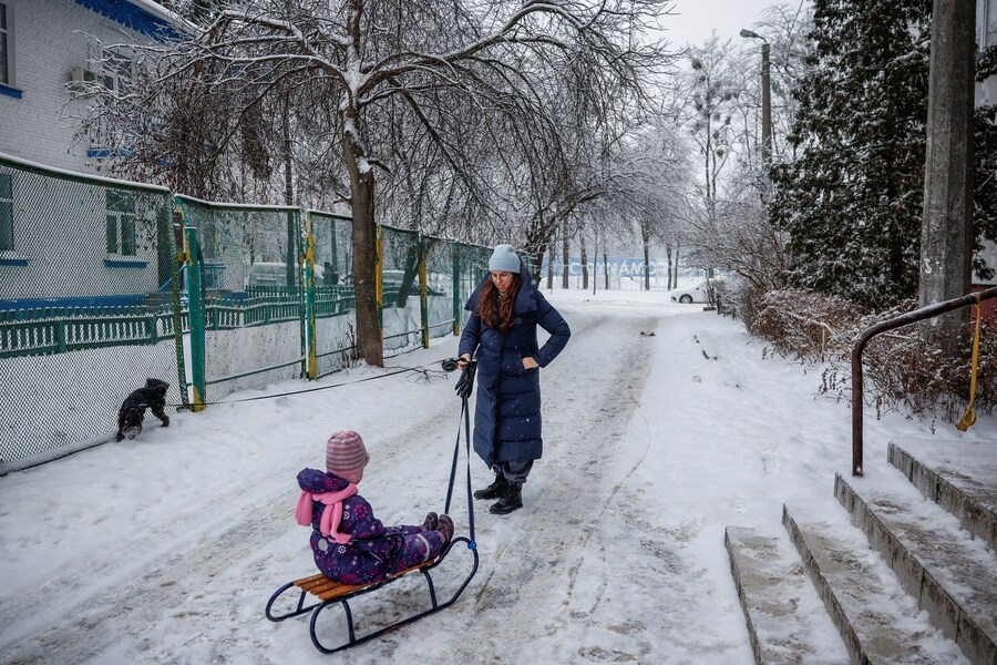 Yuliia Chumak, 32 anni, incinta di otto mesi, trascina la figlia Kvitoslava di 3 anni su una slitta mentre passeggiano nel loro quartiere durante un'interruzione di corrente. Kiev, Ucraina, 14 gennaio 2026. REUTERS/Alina Smutko (REUTERS)