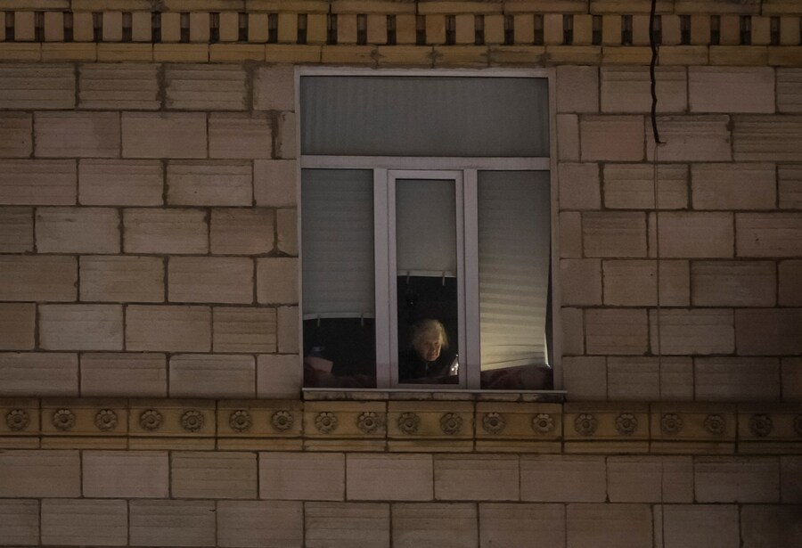 Un residente guarda fuori dalla finestra durante un blackout elettrico dopo che le infrastrutture civili critiche sono state colpite dai recenti attacchi missilistici russi a Kiev. 15 gennaio 2026. (REUTERS)