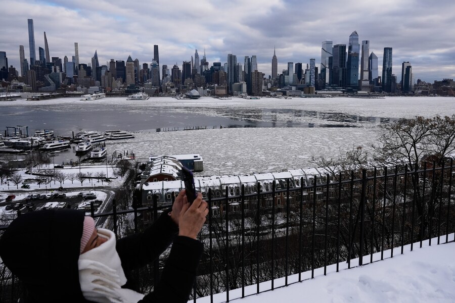 Una donna scatta una foto dello skyline di New York City e del ghiaccio sul fiume Hudson, da Weehawken, New Jersey, lunedì 26 gennaio 2026. (AP Photo/Seth Wenig) (APN)