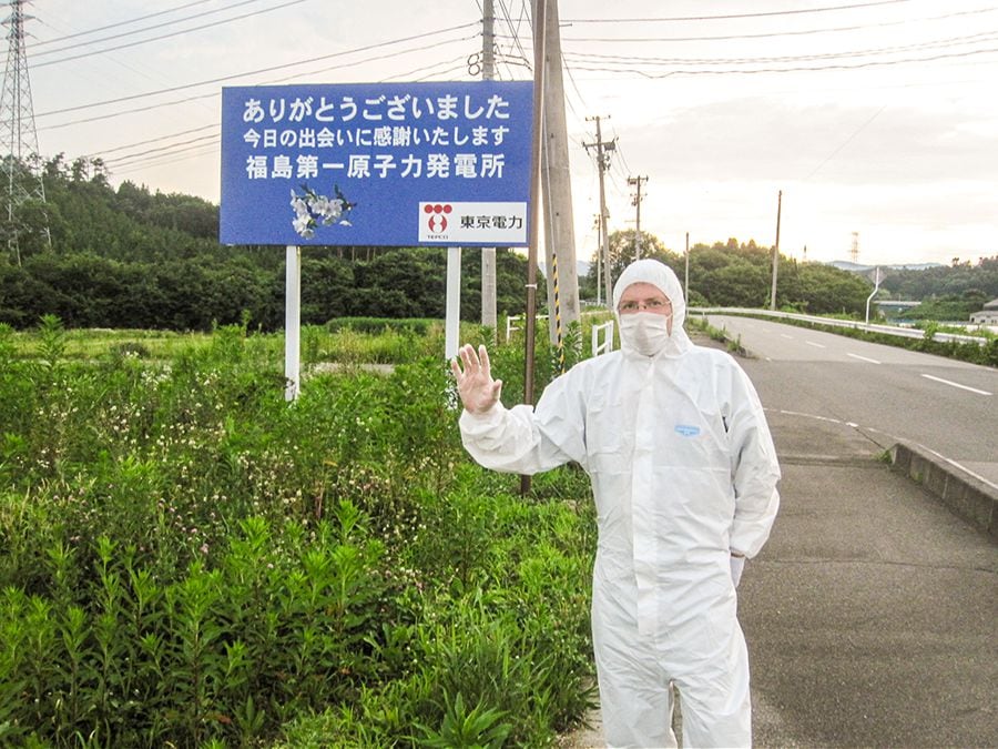 Stefano Carrer vicino alla centrale. Il cartello recita: «Grazie per avermi incontrato»