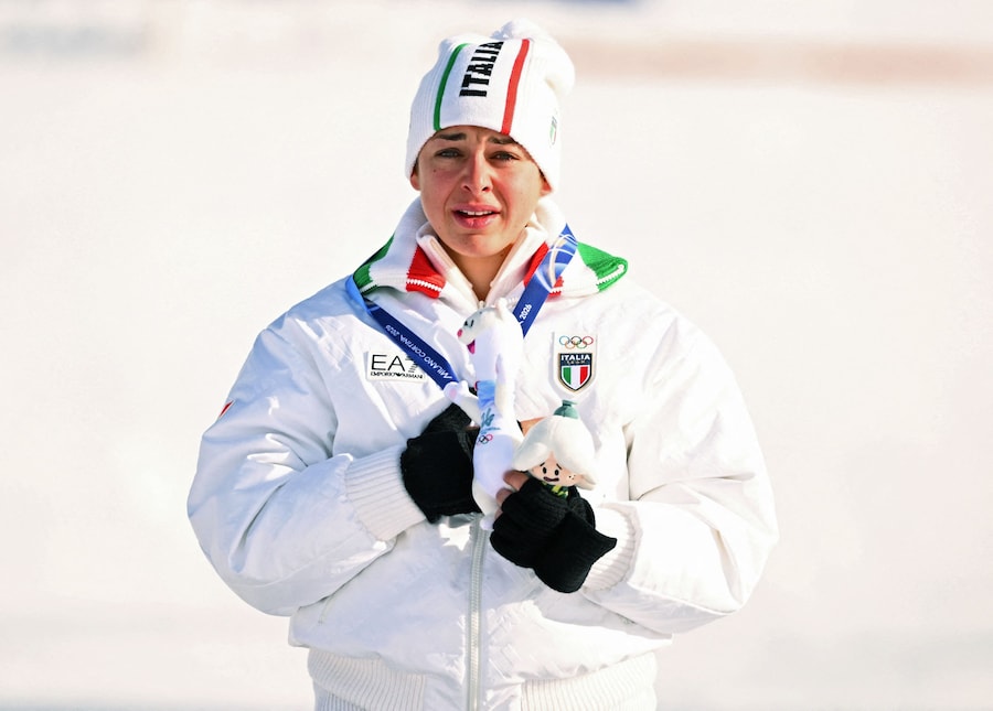 Olimpiadi Milano Cortina 2026 - Snowboard - Cerimonia di premiazione dello slalom gigante parallelo femminile - Livigno Snow Park, Livigno, Italia - 8 febbraio 2026. La medaglia di bronzo Lucia Dalmasso dell'Italia reagisce durante la cerimonia. (REUTERS/Dylan Martinez)