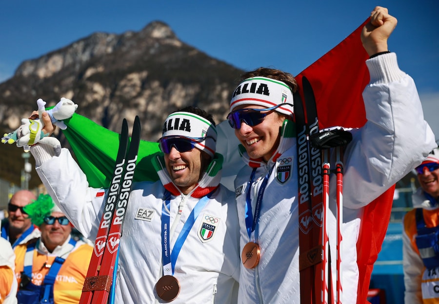 I medagliati di bronzo Elia Barp e Federico Pellegrino, entrambi italiani, reagiscono durante la cerimonia di premiazione della gara di sprint libero a squadre maschile delle competizioni di sci di fondo ai Giochi Olimpici Invernali Milano Cortina 2026, a Tesero, Italia, il 18 febbraio 2026. (EPA/Hannibal Hanschke)