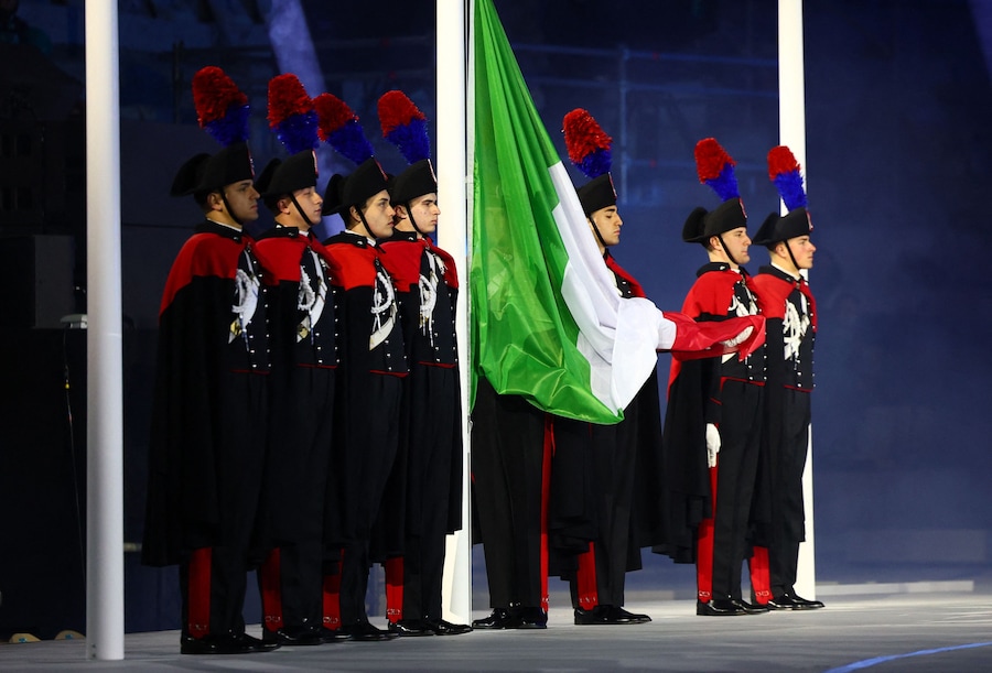 La bandiera italiana viene issata dai membri dell'esercito durante la cerimonia di chiusura. (REUTERS/Guglielmo Mangiapane)