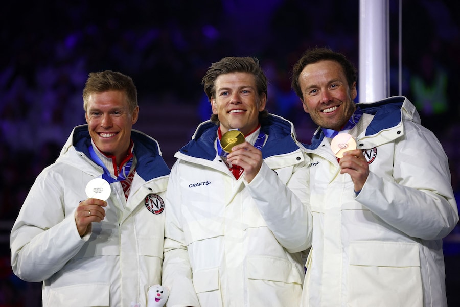 Olimpiadi Milano Cortina 2026 - Sci di fondo - Cerimonia di premiazione della gara maschile 50 km Mass Start Classic - Arena Olimpica di Verona, Verona, Italia - 22 febbraio 2026. Il medaglia d'oro Johannes Hoesflot Klaebo della Norvegia festeggia sul podio dopo aver vinto la gara maschile 50 km Mass Start Classic insieme al medaglia d'argento Martin Loewstroem Nyenget della Norvegia e al medaglia di bronzo Emil Iversen della Norvegia. (REUTERS/Guglielmo Mangiapane)