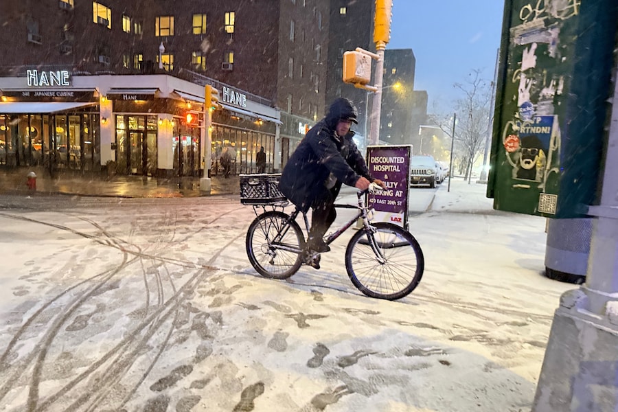 Un uomo in sella alla sua bicicletta all'inizio di una violenta tempesta di neve tra la 20esima strada e la First Avenue, domenica 22 febbraio 2026, a New York. ( (APN)