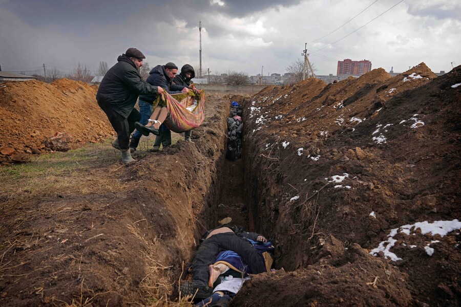 I corpi vengono deposti in una fossa comune alla periferia di Mariupol, in Ucraina, mercoledì 9 marzo 2022. (AP Photo/Evgeniy Maloletka/Associated Press/LaPresse/APN)