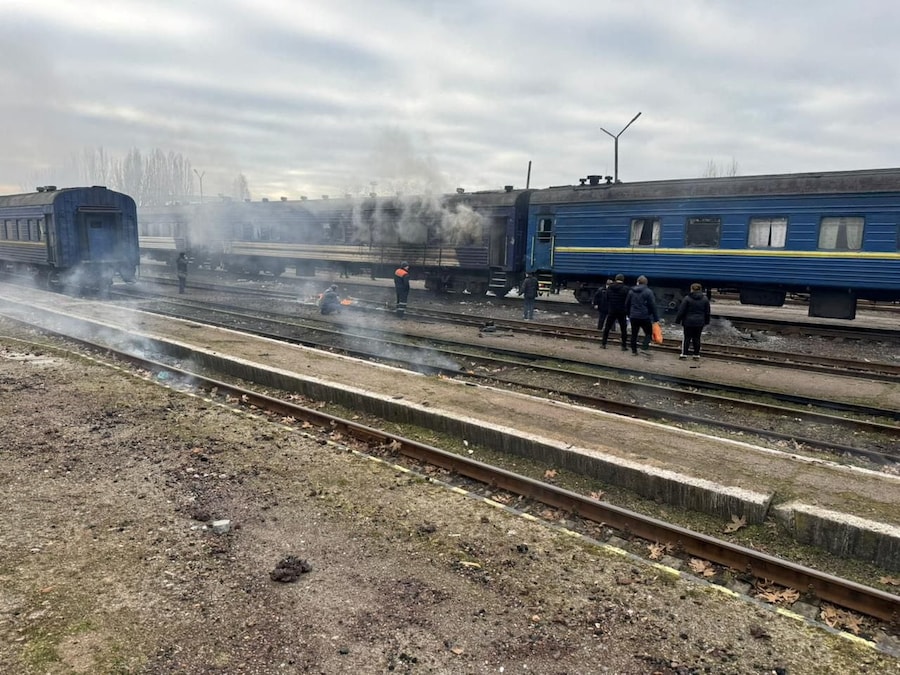 Persone in piedi accanto a un treno passeggeri dopo che è stato colpito da un attacco di droni russi in una stazione ferroviaria nella regione di Mykolaiv, Ucraina (via REUTERS)