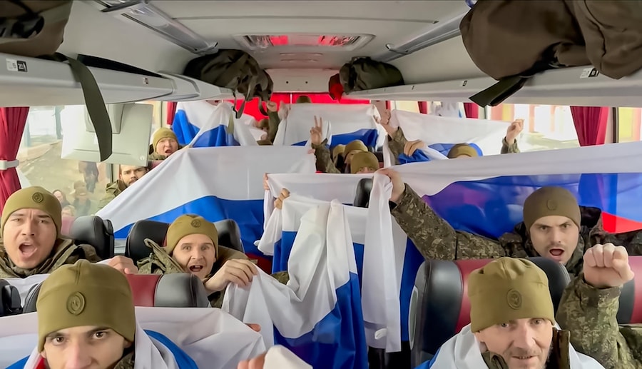 Un video distribuito dal servizio stampa del Ministero della Difesa russo mostra i prigionieri di guerra russi (POW) gioire dopo uno scambio di prigionieri in una località segreta in Bielorussia (EPA)