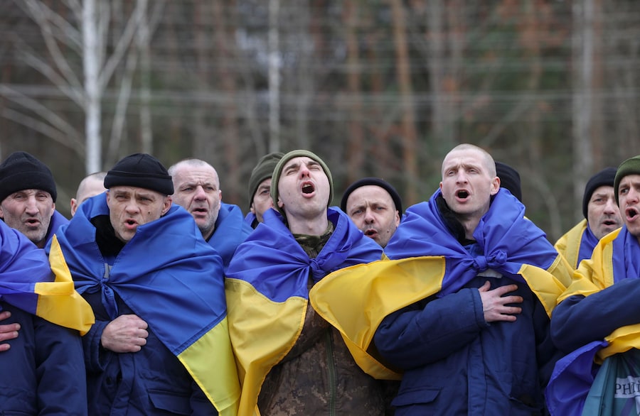 I prigionieri di guerra ucraini (POW) esultano dopo uno scambio di prigionieri in una località segreta in Ucraina (EPA)