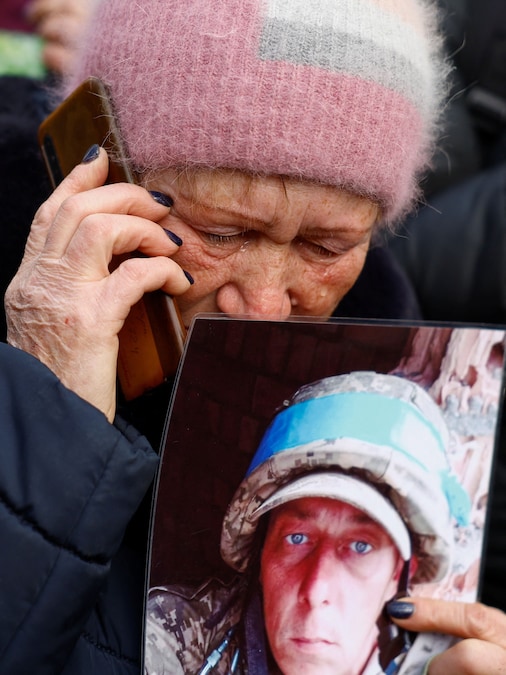 Una donna parla al telefono con suo figlio, un prigioniero di guerra ucraino (POW) liberato, mentre torna dopo uno scambio in una località segreta in Ucraina (REUTERS)
