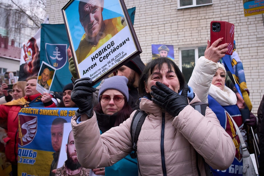 Le persone tengono in mano le foto dei loro cari scomparsi mentre i soldati ucraini tornano dalla prigionia durante uno scambio di prigionieri di guerra tra Russia e Ucraina nella regione di Chernyhiv, Ucraina (APN)