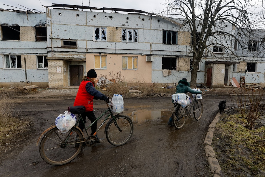 I residenti locali trasportano bottiglie d'acqua e sacchetti di plastica con generi alimentari mentre i volontari arrivano nell'insediamento di Velyka Novosilka (Velikaya Novosyolovka) per distribuire aiuti umanitari nel contesto del conflitto militare tra Russia e Ucraina nella regione di Donetsk, un'area dell'Ucraina controllata dalla Russia. REUTERS/Alexander Ermochenko (REUTERS)