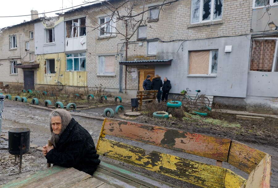 I residenti locali si radunano fuori da un edificio danneggiato mentre i volontari arrivano nell'insediamento di Velyka Novosilka (Velikaya Novosyolovka) per distribuire aiuti umanitari nel contesto del conflitto militare tra Russia e Ucraina nella regione di Donetsk, un'area dell'Ucraina controllata dalla Russia. REUTERS/Alexander Ermochenko (REUTERS)