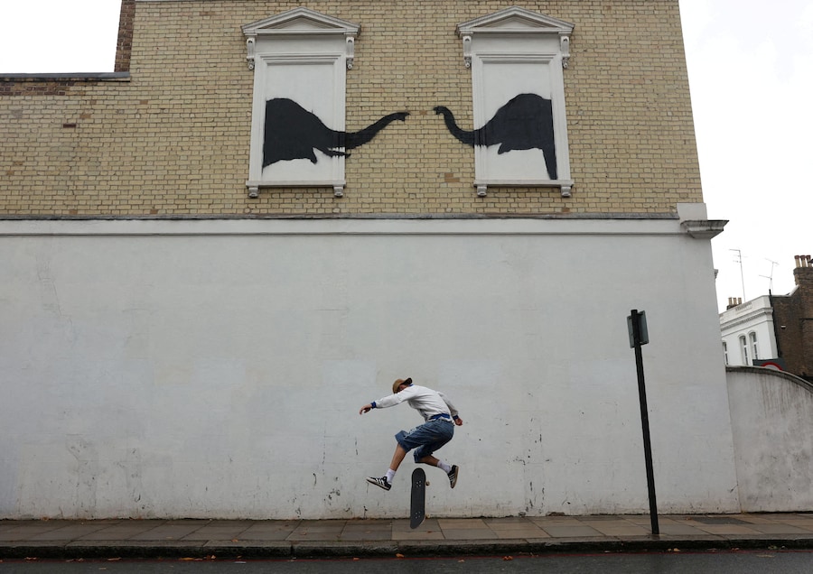 Una persona su uno skateboard passa accanto a una nuova opera dell'artista britannico Banksy, a Fulham, Londra, Gran Bretagna, il 6 agosto 2024. REUTERS/Mina Kim (REUTERS)