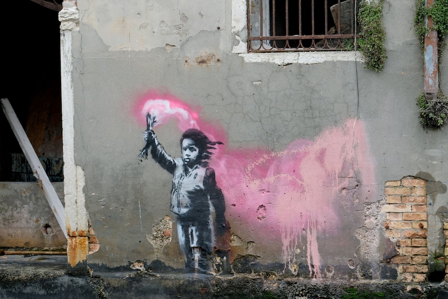 Un murale raffigurante un bambino migrante con indosso un giubbotto di salvataggio e con in mano un razzo di segnalazione rosa, lungo un canale a Venezia, Italia, il 15 maggio 2019. Foto scattata il 15 maggio 2019. REUTERS/Manuel Silvestri (REUTERS)