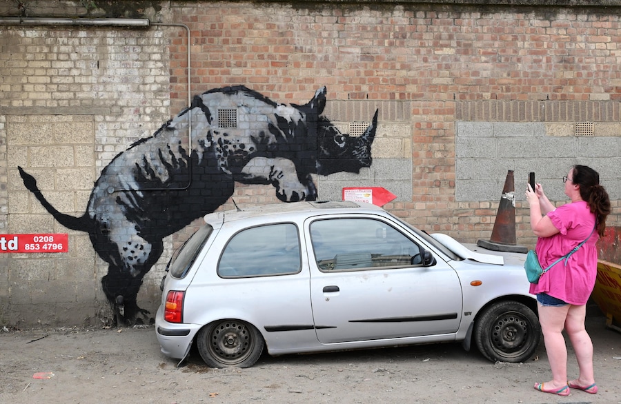 Un passante scatta una foto a una nuova opera d'arte a tema animale dell'artista di strada britannico Banksy, raffigurante un rinoceronte su un muro, a Charlton, nel sud-est di Londra, Gran Bretagna, il 12 agosto 2024. Si tratta dell'ottava opera d'arte dedicata agli animali che l'artista britannico ha realizzato negli ultimi otto giorni in vari punti di Londra. EPA/ANDY RAIN (EPA)
