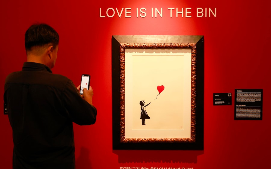 Un uomo scatta una foto mentre osserva l'opera dell'artista britannico Banksy intitolata "Girl with Balloon" presso la sala espositiva Ground Seoul a Seul, in Corea del Sud, il 23 settembre 2024. La mostra è aperta dal 10 maggio al 20 ottobre 2024 a Seul con il tema "REAL BANKSY: Banksy is NOWHERE" e presenta oltre 130 opere, tra cui 29 dipinti della serie "Pest Control" con licenza ufficiale. EPA/JEON HEON-KYUN (EPA)