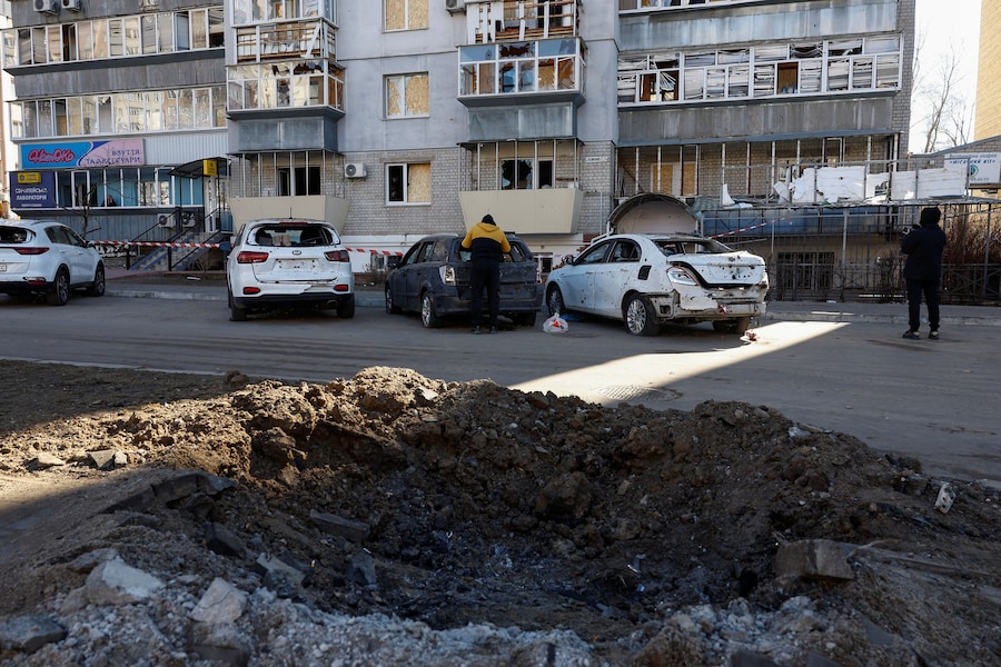 Alcuni residenti si trovano accanto a un cratere causato dagli attacchi notturni con missili e droni russi, nel contesto dell'offensiva russa contro l'Ucraina, nella città di Brovary, nella regione di Kiev. (REUTERS/Valentyn Ogirenko)