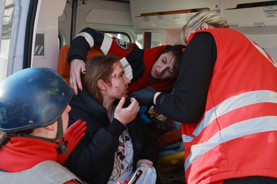 I paramedici prestano soccorso a una donna ferita in seguito a un attacco aereo russo con bombe guidate a Zaporizhzhia. (AP/Kateryna Klochko/APN)