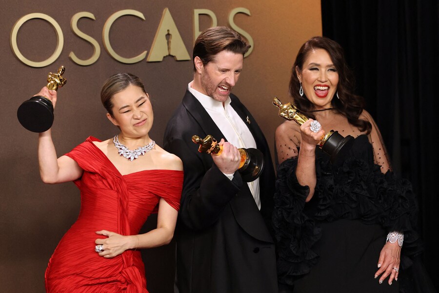 Maggie Kang, Chris Appelhans e Michelle L.M. Wong posano con l'Oscar al miglior film d'animazione per "KPop Demon Hunters". (REUTERS)