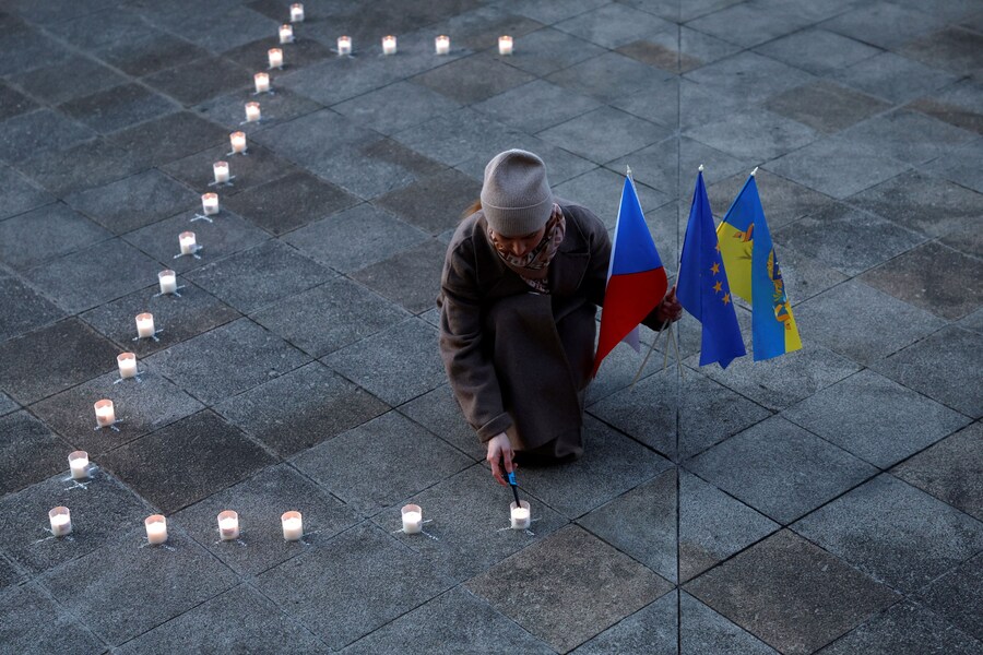 Una donna accende una candela per formare una gigantesca scritta che recita "Bambini" in russo sulla terrazza del Teatro Nazionale durante una manifestazione commemorativa per il quarto anniversario del bombardamento russo sul Teatro Drammatico di Mariupol, che causò la morte di centinaia di persone rifugiate all'interno, nel contesto dell'invasione russa dell'Ucraina, a Praga, Repubblica Ceca, il 16 marzo 2026. REUTERS/David W Cerny (REUTERS)
