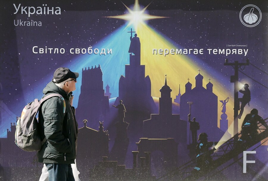 People walk past a large board with the slogan 'The light is winning the darkness' on the central street of Khreshchatyk in downtown Kyiv, Ukraine, 16 March 2026, amid the ongoing Russian invasion. EPA/SERGEY DOLZHENKO (EPA)