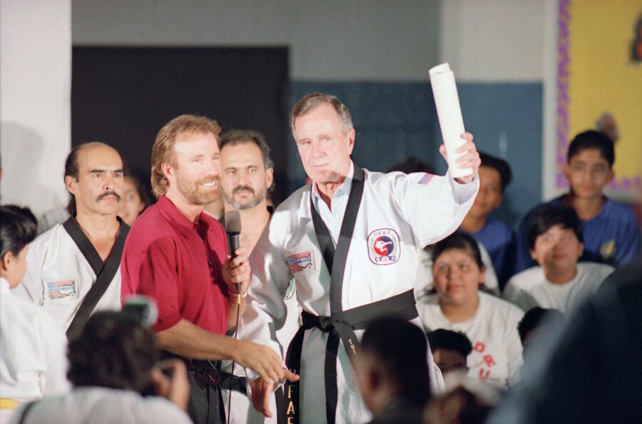 Il presidente Bush indossa un'uniforme onoraria e una giacca da cintura nera mentre si unisce all'attore ed esperto di arti marziali Chuck Norris in una scuola di Houston. (ASSOCIATED PRESS)