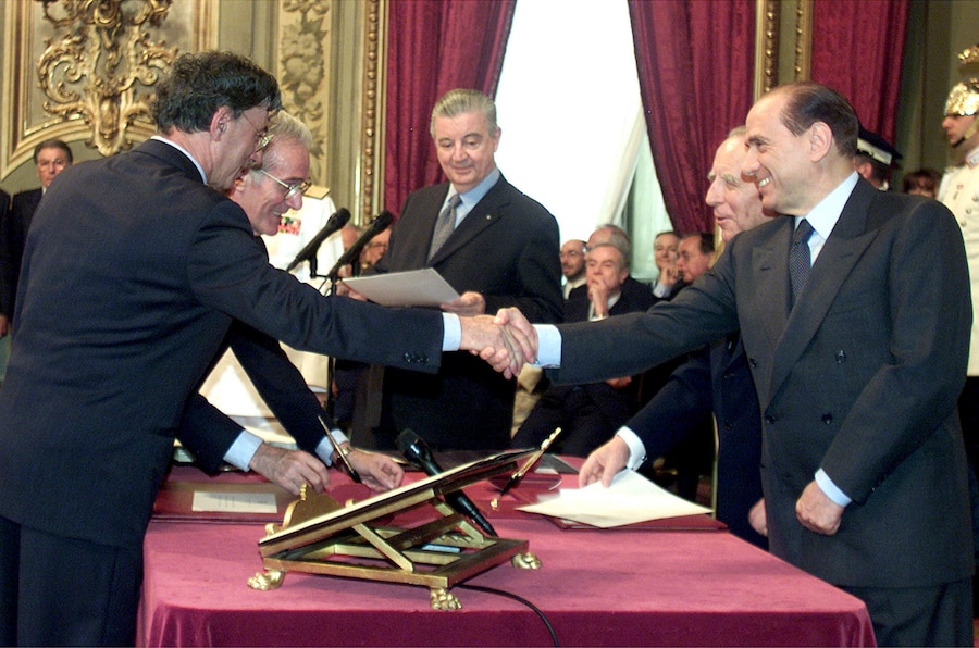 In una foto del 2001 il nuovo ministro delle Riforme Umberto Bossi stringe la mano al nuovo presidente del Consiglio Silvio Berlusconi al Quirinale durante la cerimonia di giuramento del nuovo governo. (ANSA)